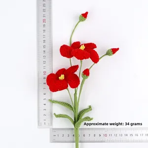 Vue détaillée d'un bouquet de fleurs rouges au crochet fait main avec règle de mesure