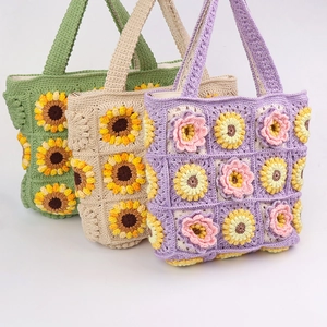 Dettaglio di borse tote girasole fatte a mano all'uncinetto in toni verde, beige e viola