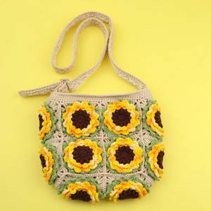 Handmade crochet sunflower crossbody bag with woven cotton straps on yellow background