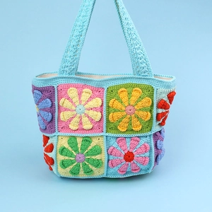 Handmade crochet tote bag with colorful daisy flower patchwork and blue woven straps