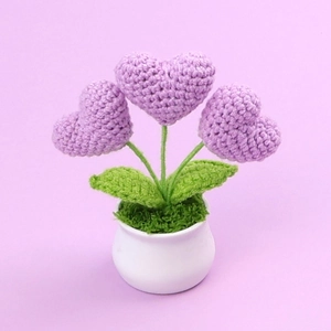 Dettaglio decorazione cuore fatta a mano all'uncinetto in vaso di ceramica con trama viola