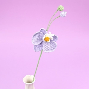 Orchidée violette crochetée à la main dans un vase en céramique blanche déco