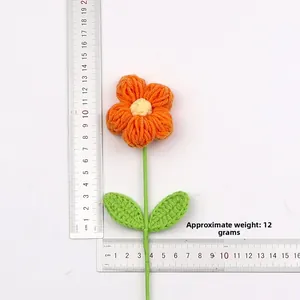 Dimensioni del fiore all'uncinetto con petali arancioni e stelo accanto a un righello