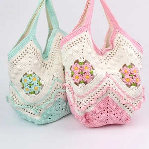 Detail of handmade crochet tote bags with 3D floral accents in green and pink pastel tones