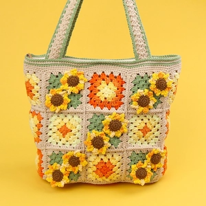 Handmade crochet sunflower tote bag with floral granny square pattern on yellow background