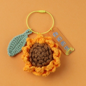 Handmade crochet sunflower keychain with green leaf on orange wire loop for bags
