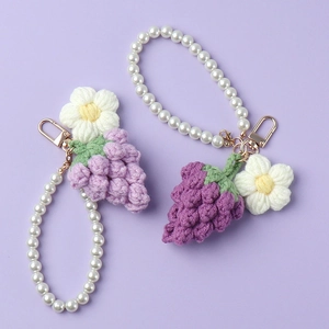 Vue détaillée du porte-clés au crochet fait main avec raisin violet et fleur blanche