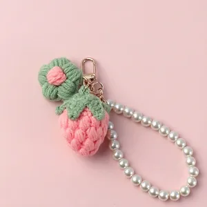 Pink handmade crochet strawberry keychain with white pearl strap and gold clasp