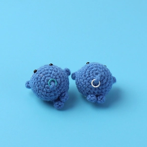 Detailed close-up of handmade crochet blue whale keychains with soft yarn texture