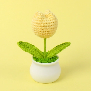 Close-up of handmade crochet yellow tulip in a white ceramic pot for home decor