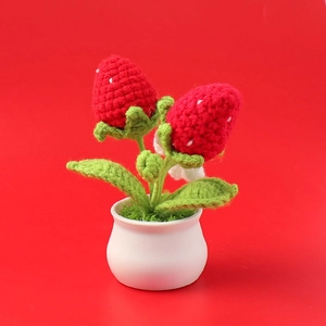 Handmade crochet strawberry potted plant detail with white ceramic base and red fruit