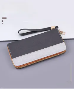 Macro detail of bicolor canvas men long wallet with zipper closure and wrist strap
