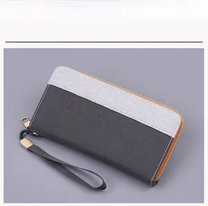 Detail of canvas wristlet wallet with grey and black patchwork and gold zipper
