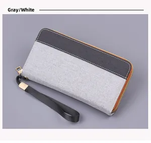 Detail of grey canvas clutch wallet with contrast stitching and metal zipper
