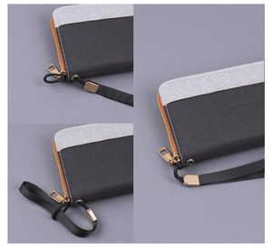 Detail of gray and black two-tone canvas clutch with metal zipper and wrist strap