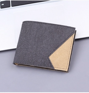 Detail of charcoal grey canvas bi-fold wallet on laptop with contrast stitching