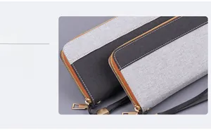 Detailed view of canvas wristlet clutch with grey and black patchwork and metal zipper