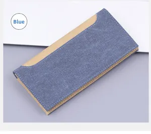 Detailed view of blue denim and khaki canvas long wallet with white stitching