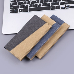 Drei lange Herren-Stoffbrieftaschen im Color-Block-Design auf grauem Grund mit Laptop