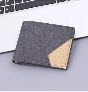 Detail of grey canvas bifold wallet with contrast khaki patchwork on laptop desk