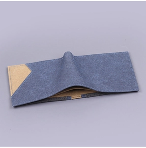 Detail view of denim and khaki canvas bifold wallet with reinforced blue stitching