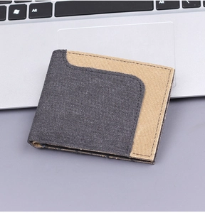 Close-up of bicolor canvas bifold wallet with precise stitching next to a laptop