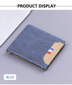 Blue canvas bifold wallet with flag tag detail and khaki patch on gray background