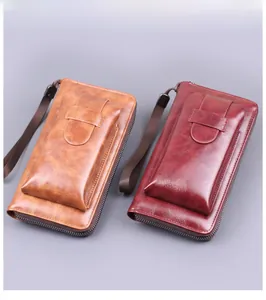Brown and burgundy long zipper wallets with oil wax texture and wrist strap detail