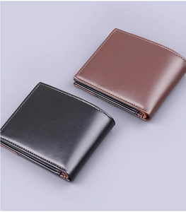 Detail view of black and dark brown men's bi-fold wallets with textured leather and stitching