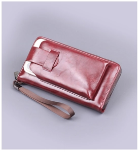 Macro view of high-quality burgundy leather wallet showing zipper and front phone pocket