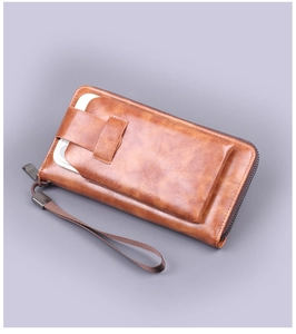 Macro view of a brown leather wallet with a zipper closure and a smartphone pocket detail