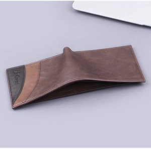 Detail of bifold men's wallet in brown leather with textured finish and stitching