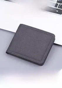 Detail of dark grey canvas bifold wallet featuring refined stitching and wear-resistant fabric