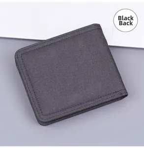 Rear view of minimalist black canvas short wallet with fine stitching on fabric surface