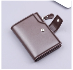 Detail of dark brown faux leather trifold wallet with snap button and zipper pocket