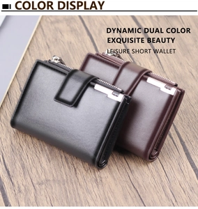 Close-up of matte leather wallets with zipper pocket and metal snap on wood surface