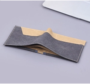 Détail d'un portefeuille en denim avec coutures contrastées et patchwork en toile