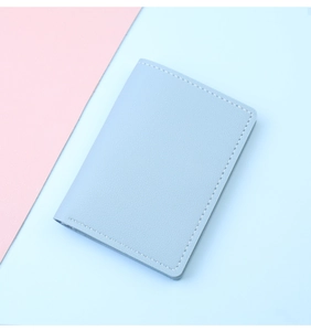 Primer plano de cartera de cuero azul claro con finas costuras blancas en contraste