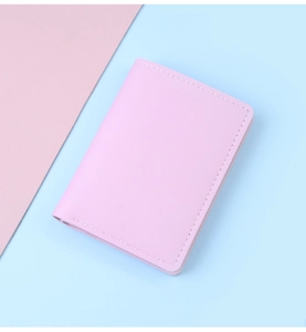 Primer plano de tarjetero de cuero rosa claro con textura de lichi y costuras blancas