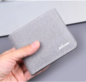 Close-up of a light grey men's bifold canvas wallet showing fabric texture and logo