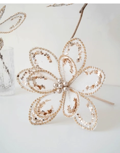 Close-up of champagne mesh Christmas flower with gold sequins and center pearls