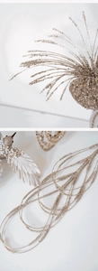 Detailed close-up of champagne gold glitter bird and beaded feathers for Christmas tree decoration