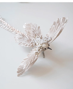Close-up of champagne artificial bird ornament with pearls and glitter details