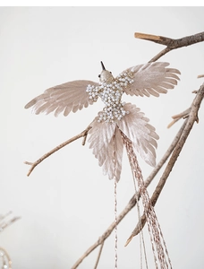 Detailed view of champagne hummingbird ornament with pearls and shimmering fringe