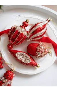 Detail of red and gold Christmas ornaments including bear and pinecone shapes on white plate