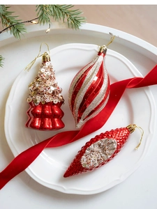 Detail of red and gold Christmas tree ornaments with sequins and glitter in a tray
