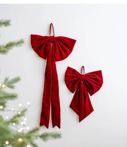 Close-up of elegant red velvet Christmas bow ornaments with long ribbons for tree decor