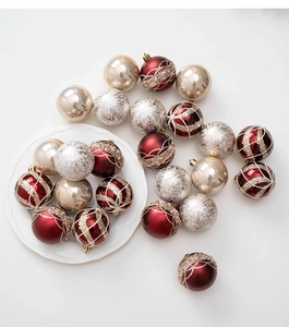 Close-up of champagne and red Christmas ornaments with glitter details on white surface
