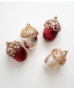 Detail of acorn Christmas ornaments in champagne and deep red with glitter and bead tops