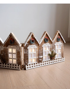 Détail de la barrière de sapin de Noël en bois avec maisons à LED chaleureuses